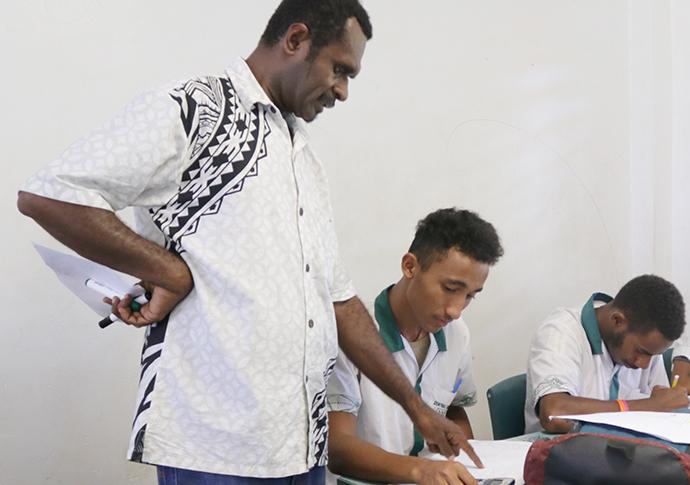A file picture of a ni-Vanuatu teacher at Central College guiding a student. A revised regional teacher competency standards will serve as an important support instrument for the Pacific's teaching profession. 